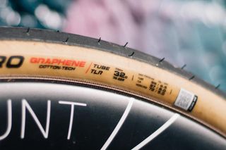 A close up of the labels on the side of a tanwall road tyre, showing a '32c' width notation.