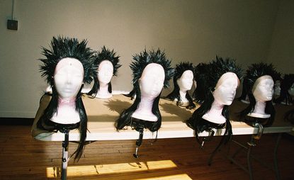 black mullet wigs designed by Julien D’ys for the Comme des Garçons show arranged on a table