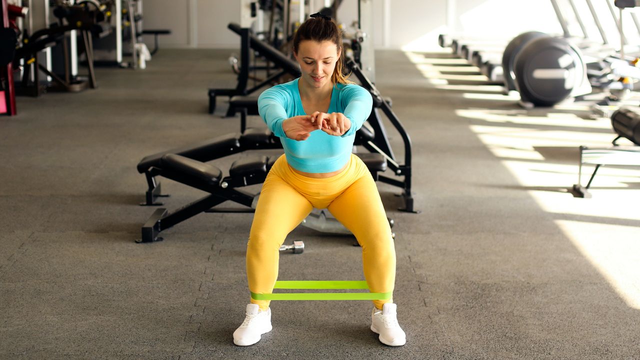 Woman holding a resistance band squat