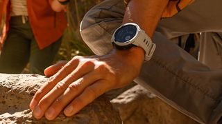 Person scrambling on rocks wearing Garmin Instinct 2