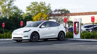 A Tesla Model Y plugged in at a Supercharger station
