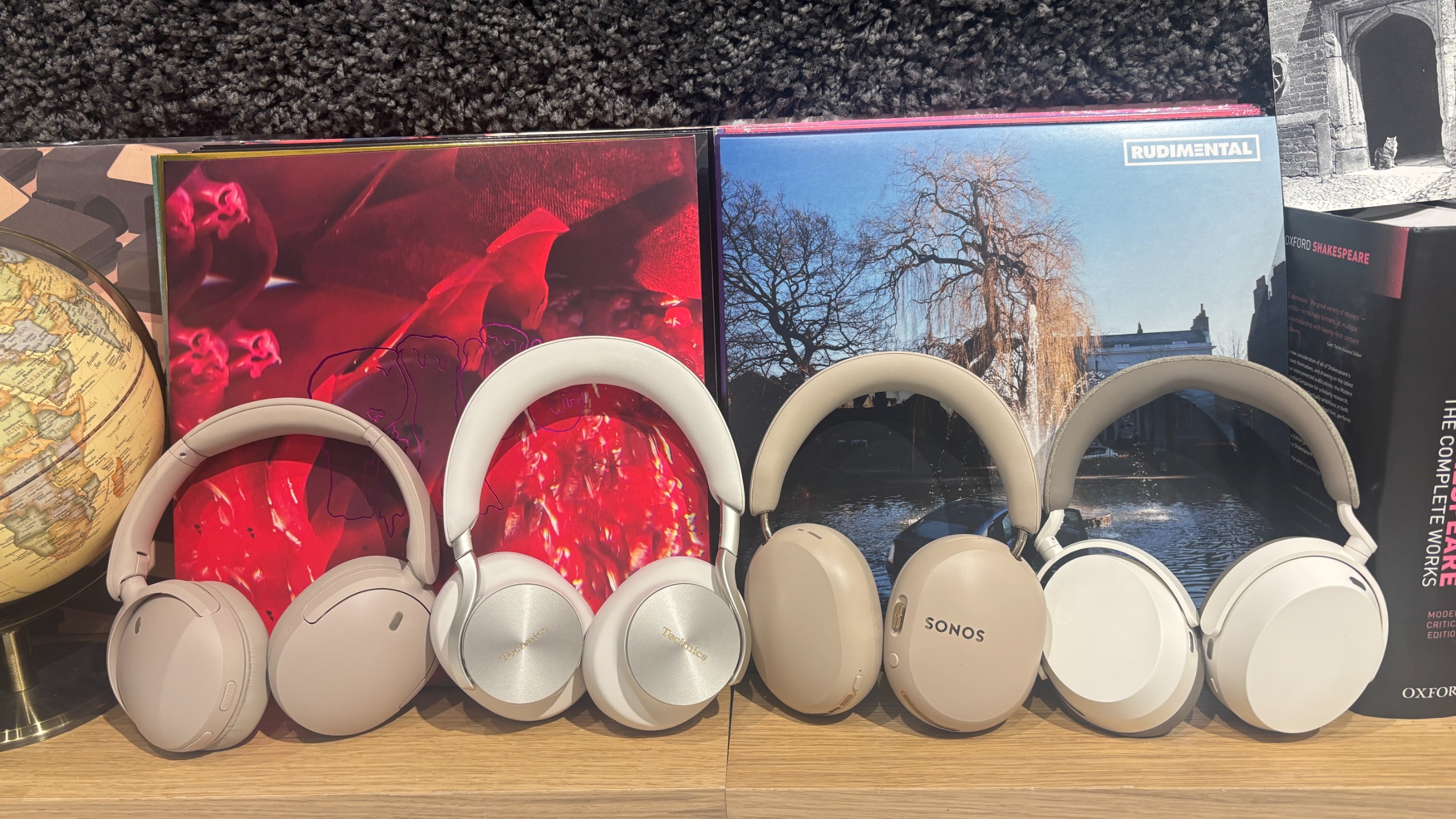 An array of wireless headphones from various brands in a test room