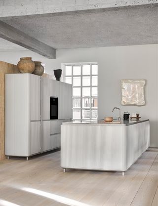 a white ribbed modern kitchen with a stainless steel worktop