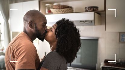 Woman and man kissing in the kitchen, representing the corkscrew sex position