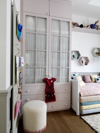 kids' closet ideas pink wardrobe in girl's bedroom with white ottoman