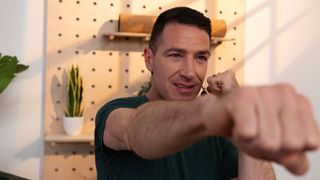 man performing a jab punching move towards the camera in a studio setting