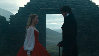 Margot Robbie and Jacob Elordi standing face-to-face outside in Wuthering Heights