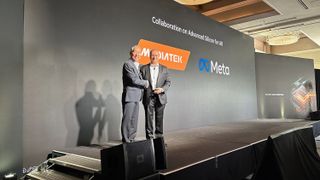 MediaTek VP Vincent Hu and Meta Reality Labs VP Jean Boufarhat shaking hands on stage at the MediaTek summit. The screen behind them announces their "collaboration on advanced silicon for AR."
