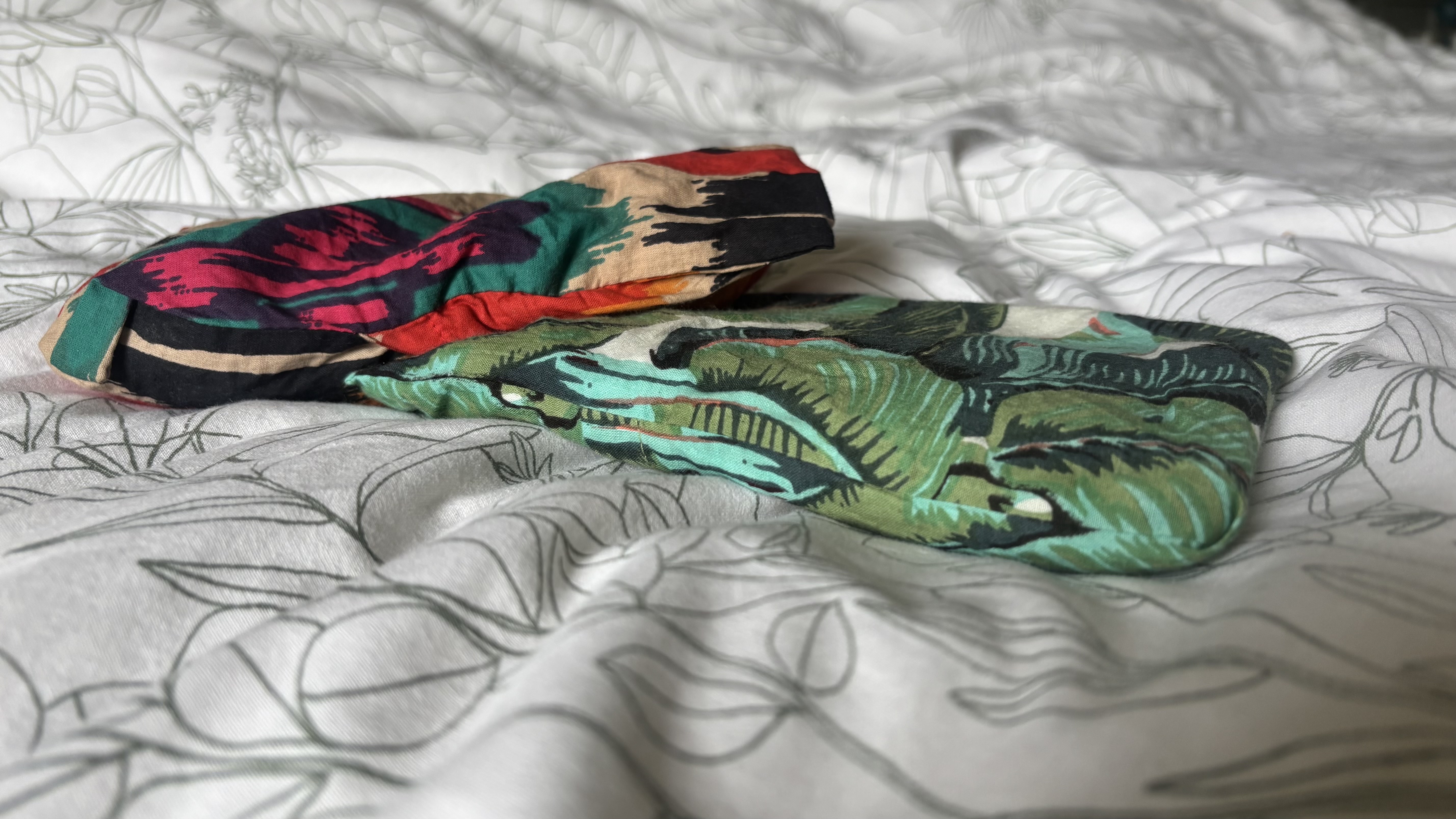 Two eye pillows posed together on a bedspread.