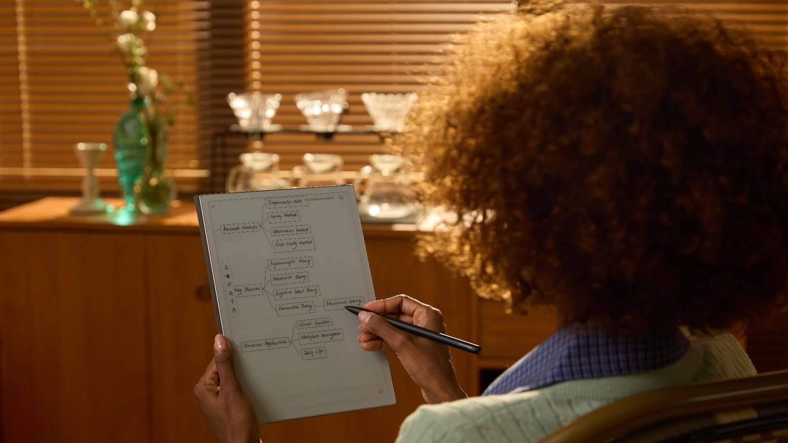 A person writing on the iFLYTEK AINOTE 2 paper tablet