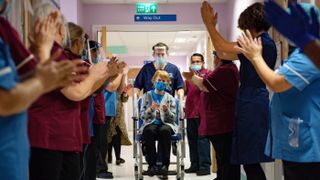 Margaret Keenan, 90, is applauded by staff as she returns to her ward after becoming the first person in the U.K. to receive the Pfizer/BioNtech COVID-19 vaccine on Dec. 8, 2020.