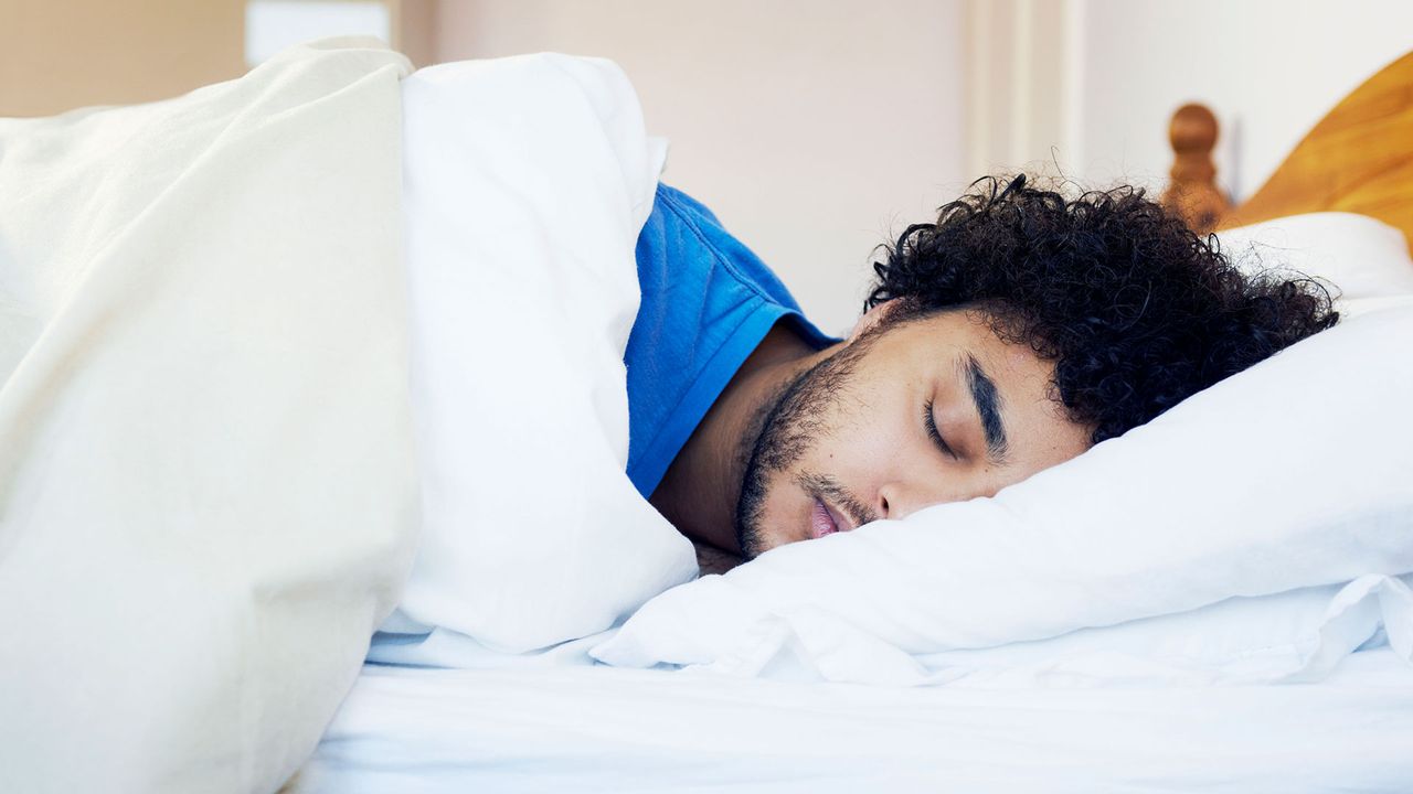 Man asleep on his side in bed