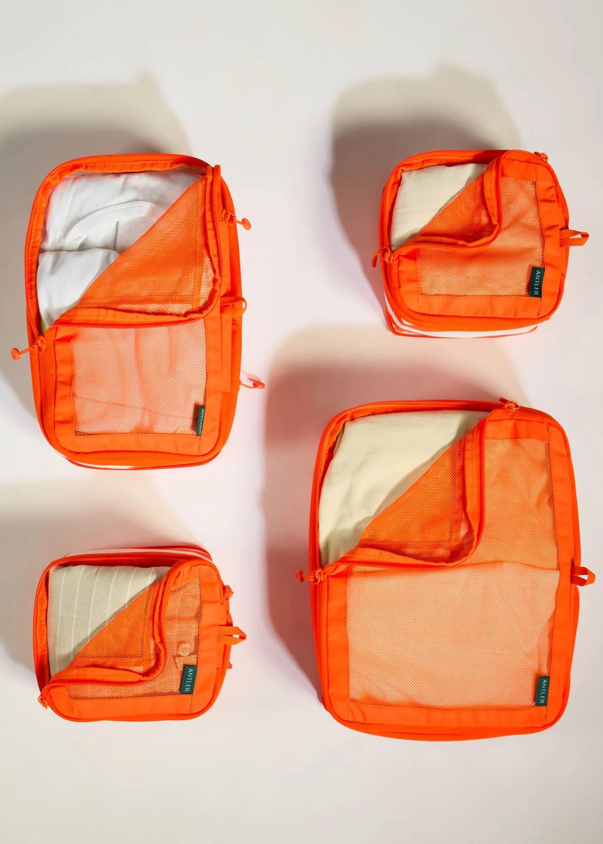 A set of four orange packing cubes from Antler