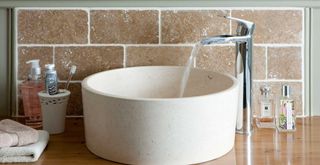 Close up image of a round stone bathroom sink basin