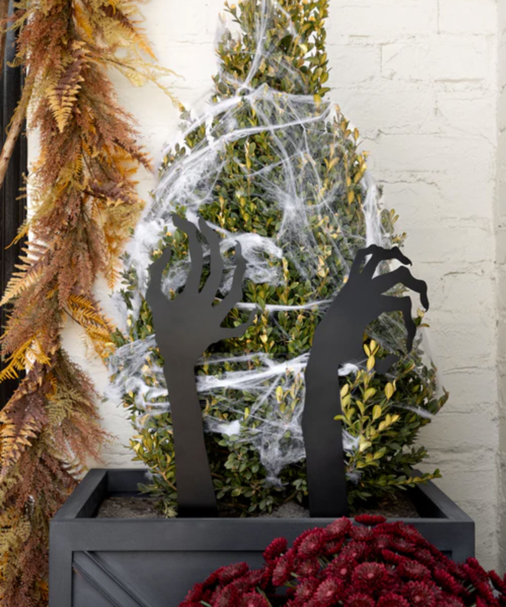 Spooky metal hands in an outdoor planter