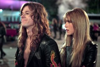 Mark Wahlberg and Jennifer Aniston wearing '80s like clothes at a concert in 'Rock Star'