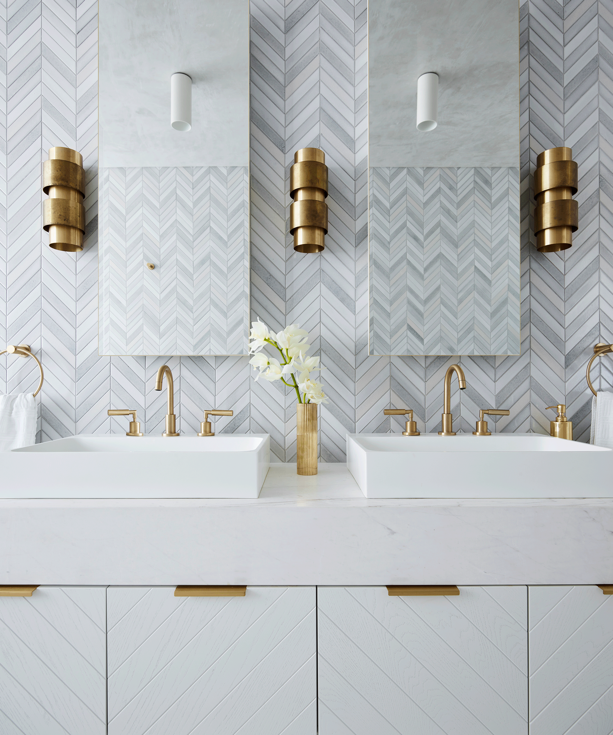 An example of bathroom wall ideas showing a white bathroom with brass accents