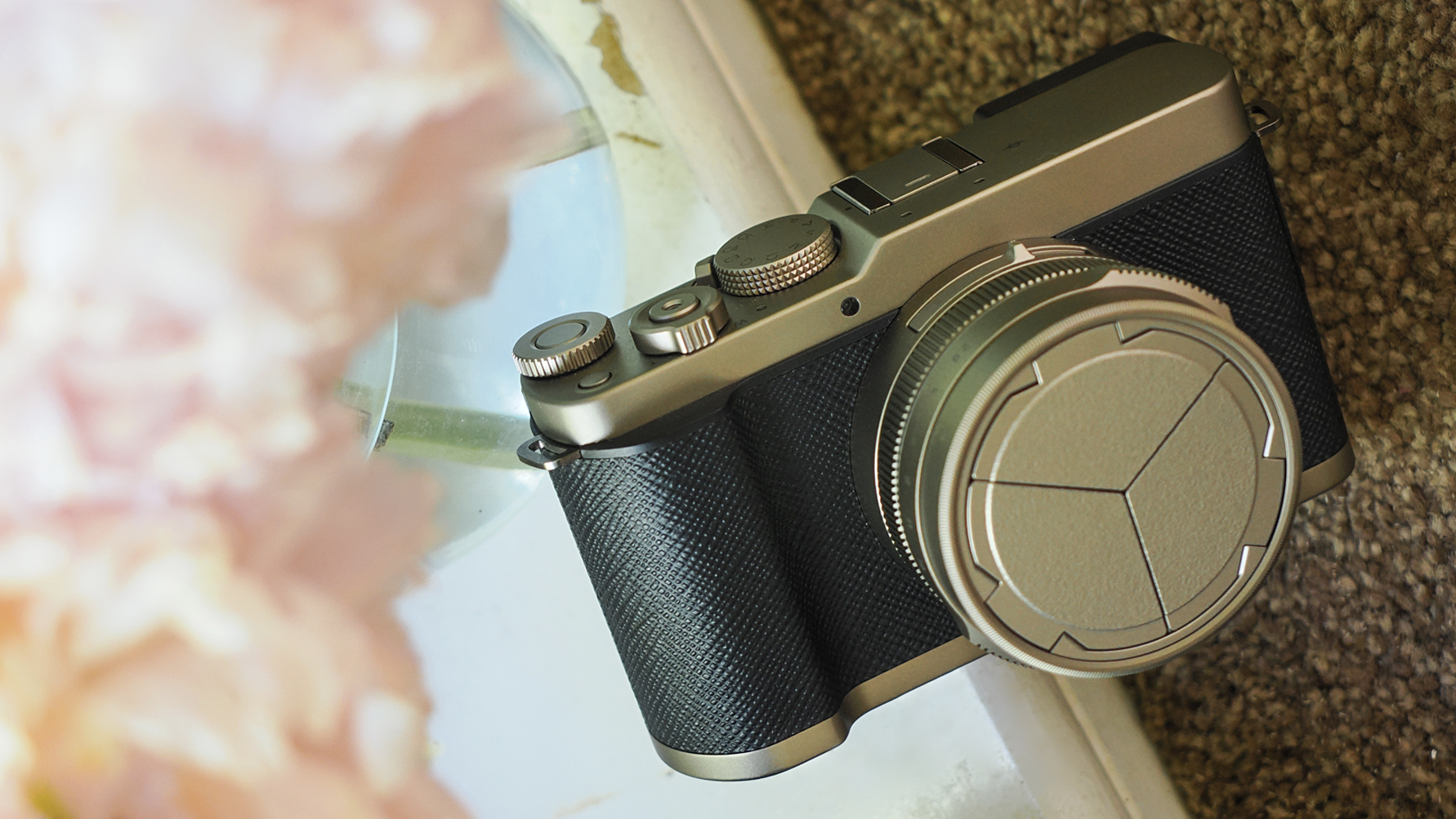 Panasonic Lumix L10 in front of a vase of flowers