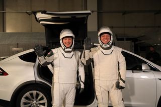 Donning their SpaceX spacesuits, NASA astronauts Doug Hurley (left) and Bob Behnken wave after walking out of the Neil A. Armstrong Operations and Checkout Building at Kennedy Space Center in Florida on Jan. 17, 2020, during a dress rehearsal ahead of the SpaceX uncrewed In-Flight Abort Test.