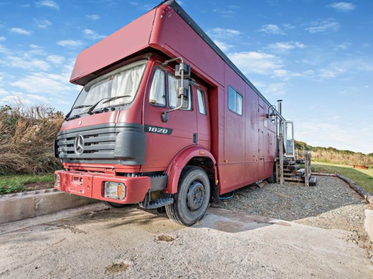 The front of the red caravan/motorhome parked on grass