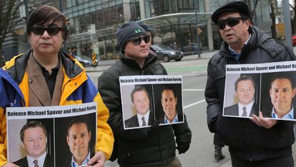 Protesters hold signs calling for the release of Canadian citizens Michael Spavor and Michael Kovrig 