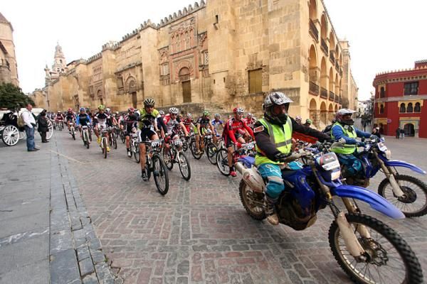 Riders follow the pace motos through Cordoba's historic center in the opening neutral section.