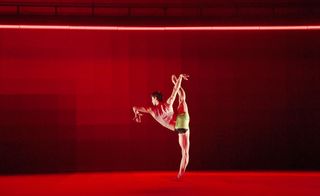 Male dancer doing a solo with red lighting