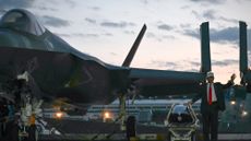 President Donald Trump stands beside an F-35 in Japan