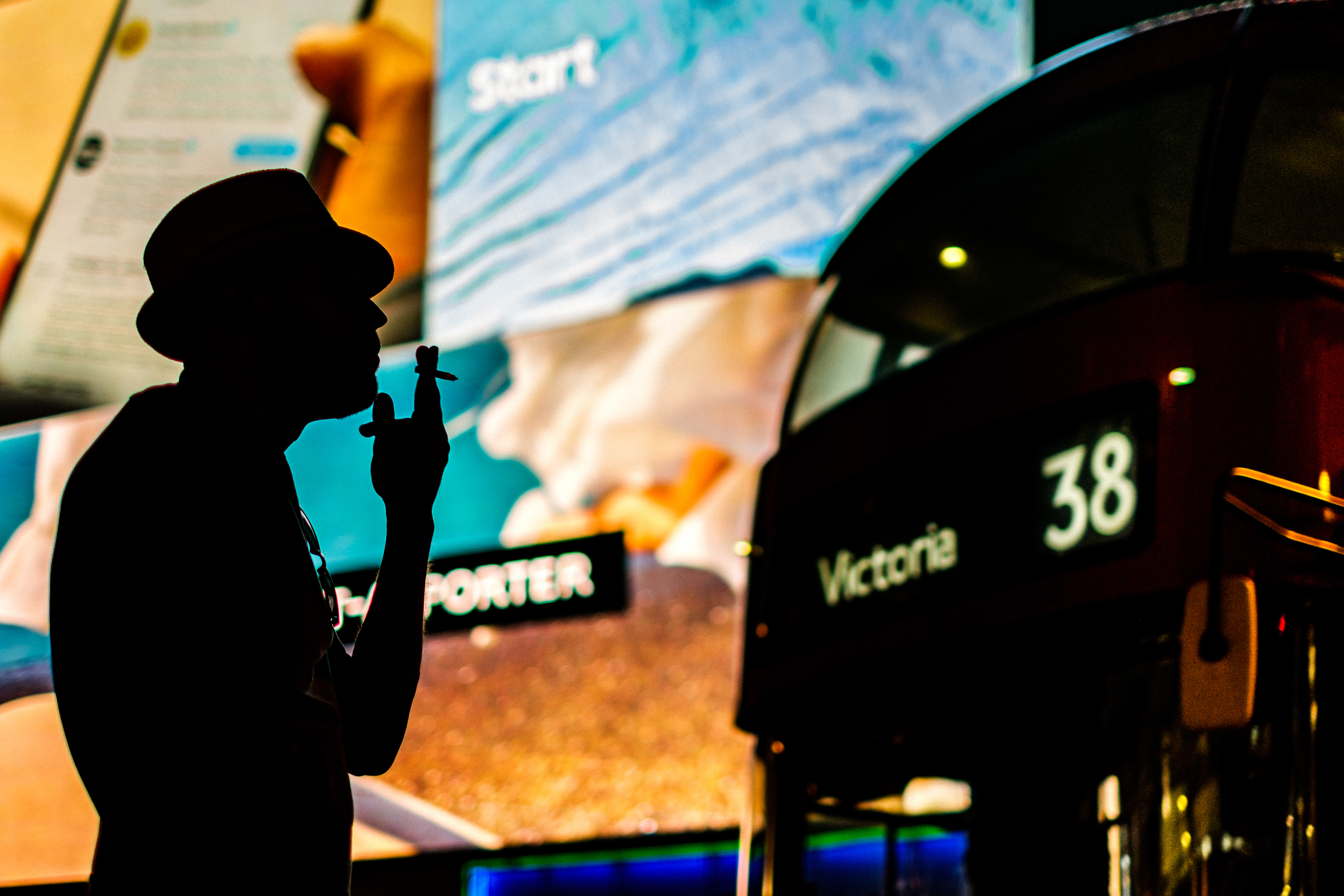 Silhouette of a man smoking in front of a London bus