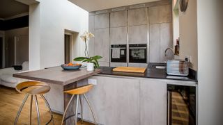 grey kitchen peninsula with raised dining area
