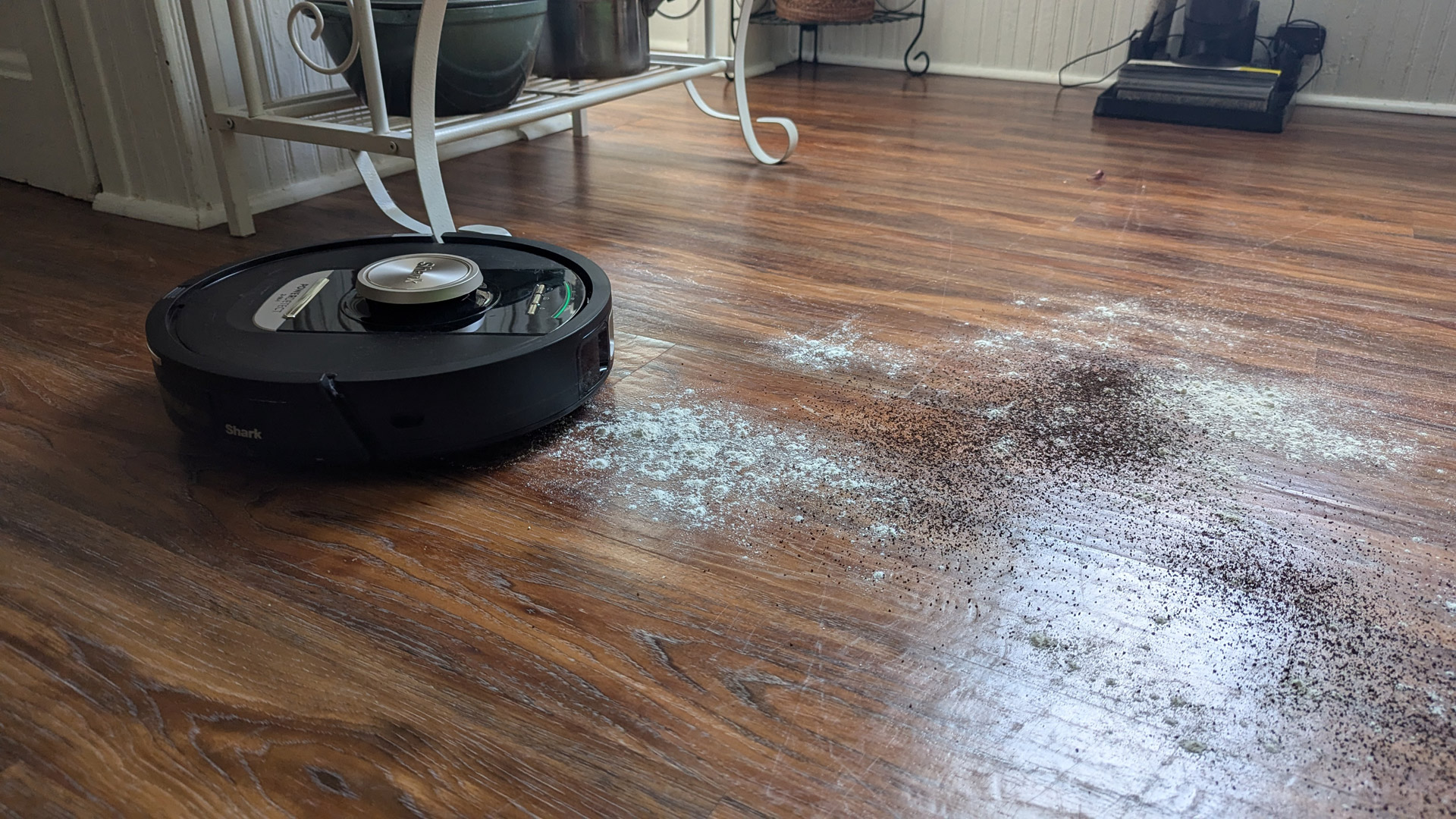 The Shark PowerDetect Robot Vacuum and Mop about to clean up flour and coffee on a hard floor