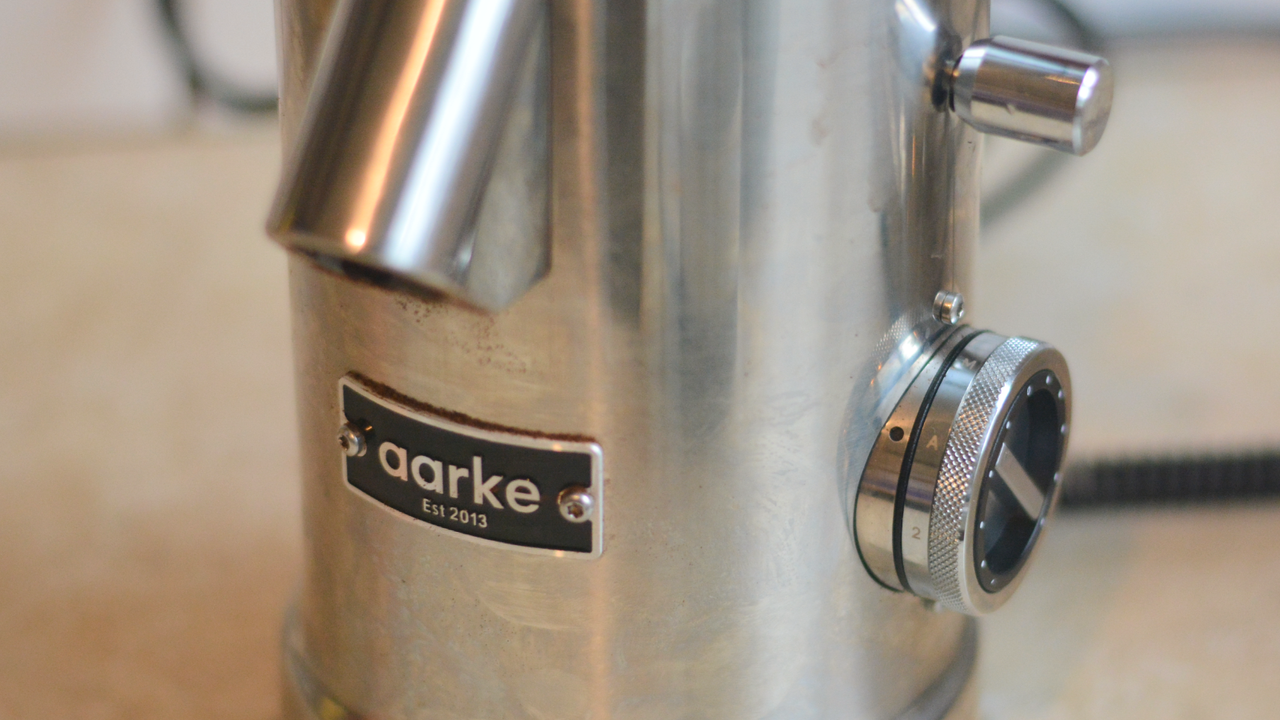 Image of the Aarke Coffee System &ndash; a stainless steel coffee bean grinder and drip coffee maker &ndash; positioned on a kitchen counter
