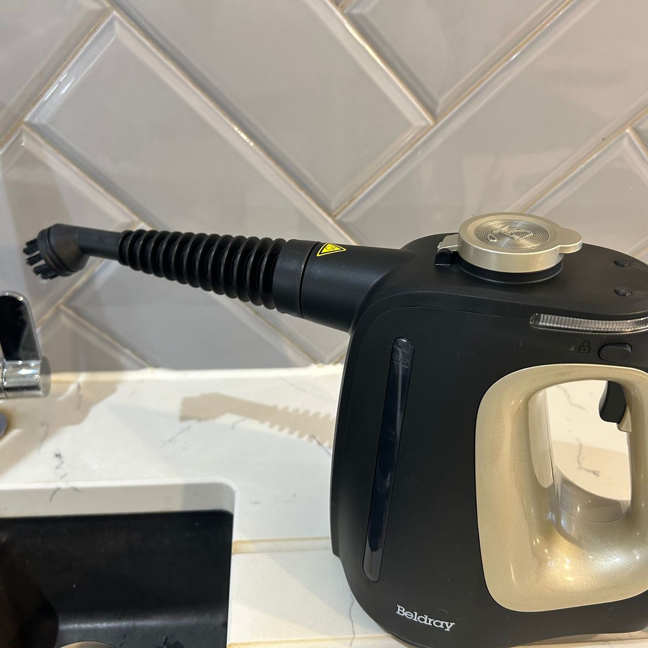 Beldray steam cleaner beside kitchen sink with round brush attachment