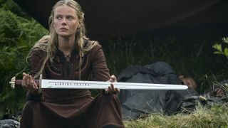 Freydis tient son épée en l'air pour quelqu'un hors champ dans Vikings Valhalla saison 2.