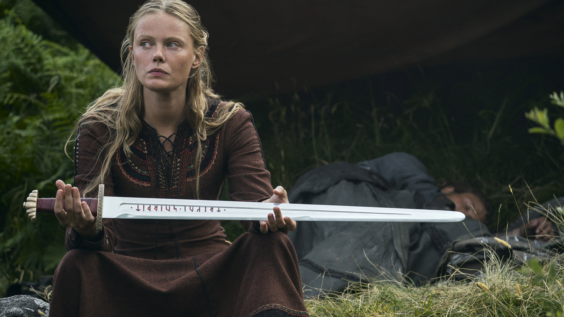 Freydis sostiene su espada en alto hacia alguien fuera de la pantalla en Vikings Valhalla temporada 2