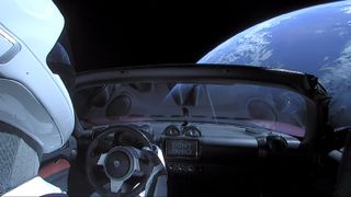 A photo taken from the backseat of the Tesla Roadster showing Starman "steering" the car