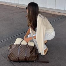 Woman wearing Louis Vuitton weekender duffel bag