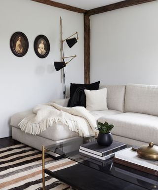 family room with white painted walls, cream l-shape sofa and black cushions and lamp
