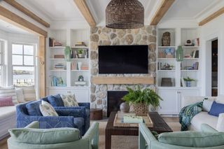 A traditional-style living room with blue, green, and white sofas arranged around the central coffee table