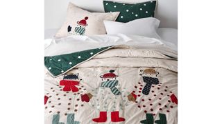 A cream Christmas bedding quilt with snow men designs.