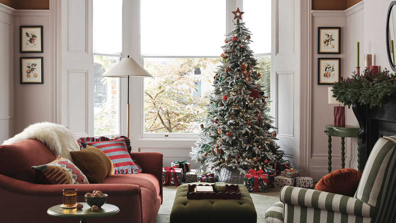 Dawn and Dusk lifestyle campaign image. There is a quiet luxury frosted tree with felt baubles, in living room with striped upholstery