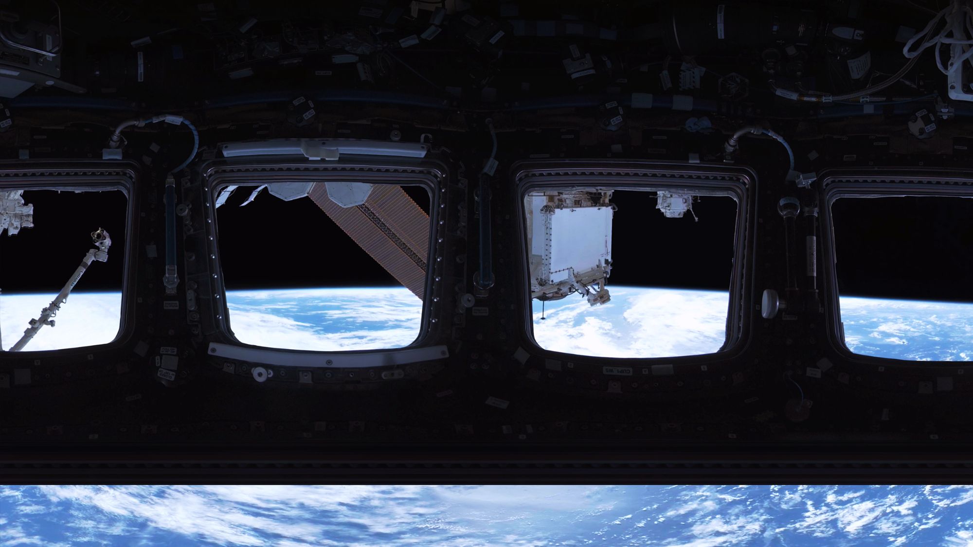 A photo showing the Earth through windows of a module.