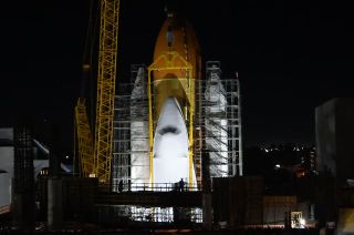 A sling and crane hold Endeavour in place as fine adjustments are made to align and attach the winged orbiter to its external tank and solid rocket boosters for display inside the Samuel Oschin Air and Space Center, Tuesday, Jan. 30, 2024.