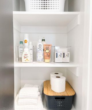 Bathroom storage shelves with bins and products neatly displayed