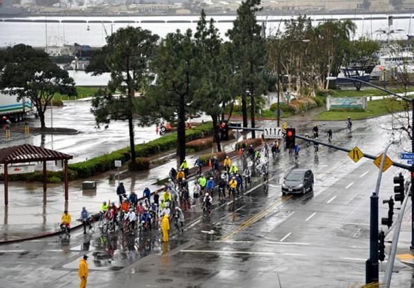 A group waits to proceed on San Diego's rain soaked streets.