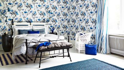 A blue bedroom with blue wallpaper and accents