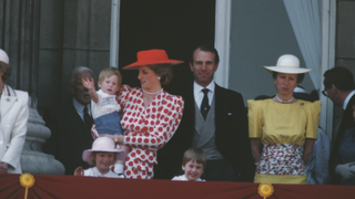 The royal family on the balcony of Buckingham Palace in London for the Trooping the Colour ceremony, June 1986. Diana, Princess of Wales (1961 - 1997) is wearing a dress from Tatters of London, and holding Prince Harry. Prince William is in front, and Princess Anne and her husband Mark Phillips are to the right.