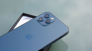 En iPhone 12 Pro fset bagfraa liggende på en æske