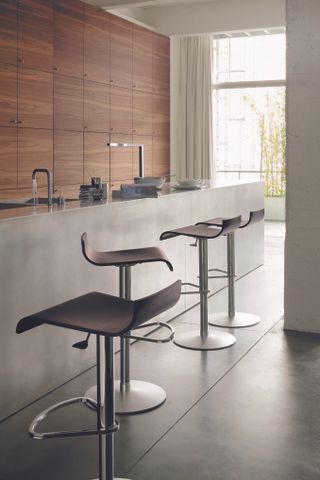 kitchen with contemporary feel, breakfst bar stools and mix of concrete and wood by ligne roset