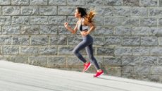 Attractive young woman running up a slope